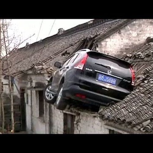 Cina. SUV perde il controllo e si ferma sul tetto di una casa. / VIDEO