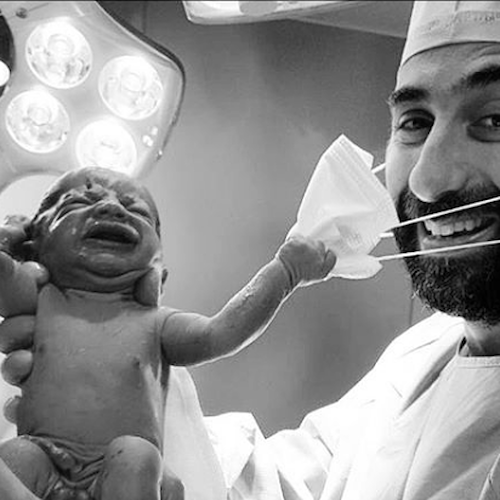 Neonato strappa mascherina al medico: lo scatto social della "speranza" è virale